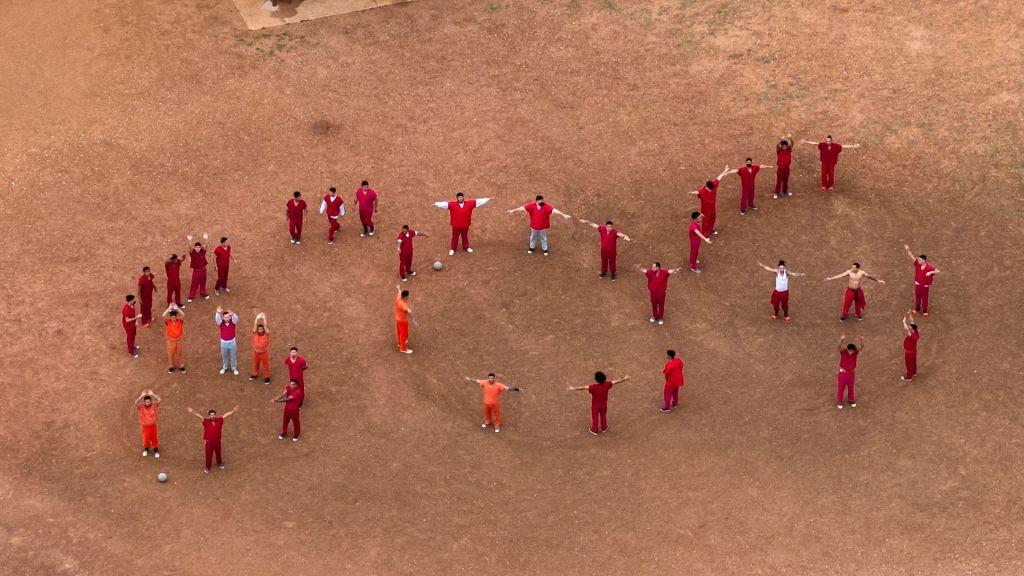 An image captured by a Reuters drone shows dozens of detainees standing in a courtyard and spelling out “SOS.”